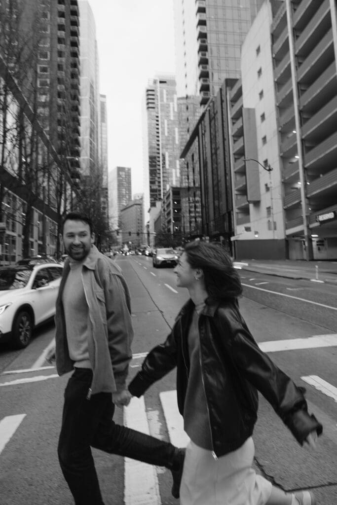 Blurry black and white photo of a man and woman running across a city crosswalk
