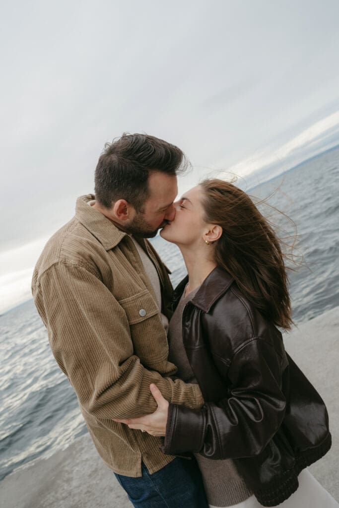 Couple kissing on a pier with Puget Sound behind them